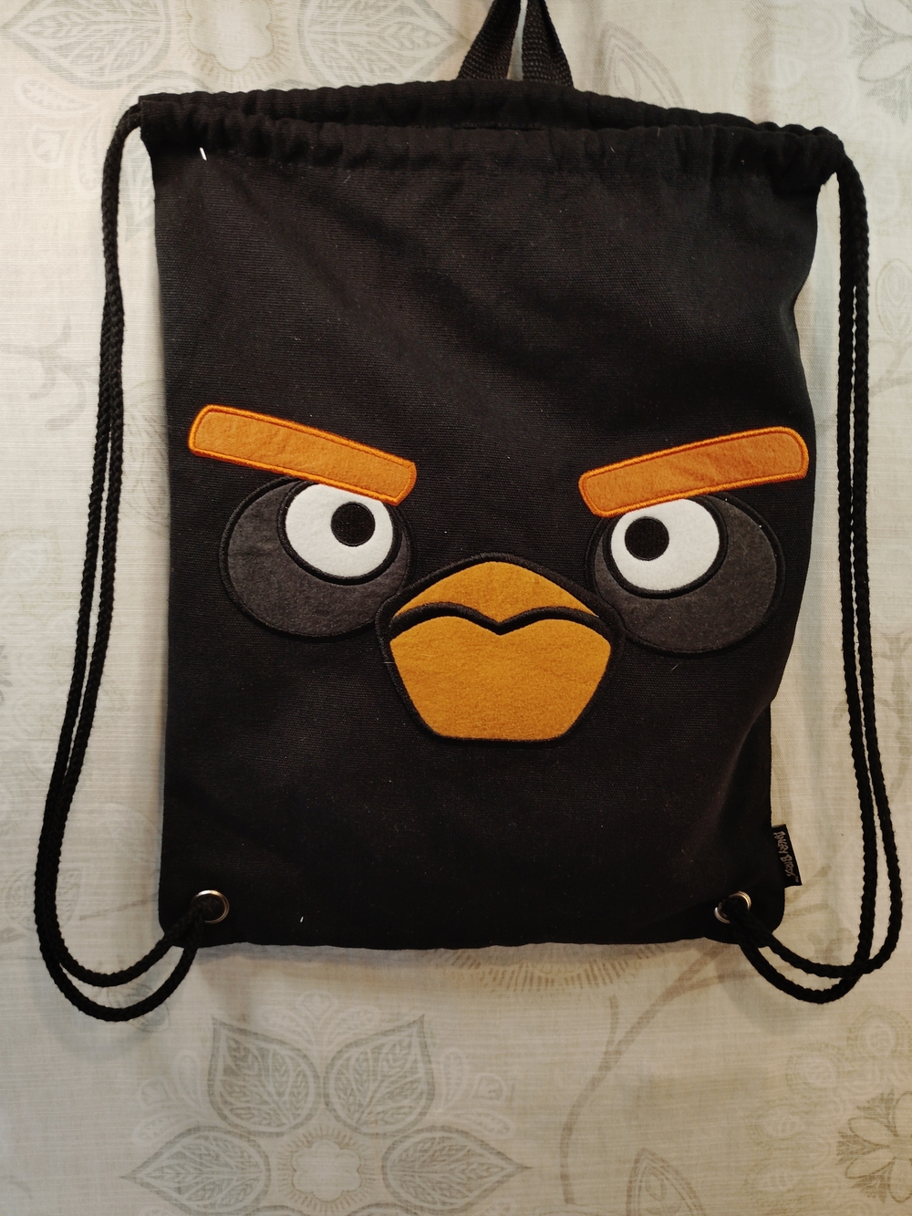 Black Angry Bird Drawstring Backpack with Orange Accents